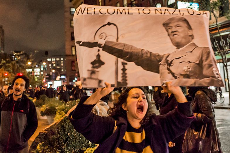 A woman holds a placard portraying Donald Trump as a Nazi, as various protests gathered in and around Manhattan and eventually marched through the streets, wending their way to Trump Tower, 9 September 2016