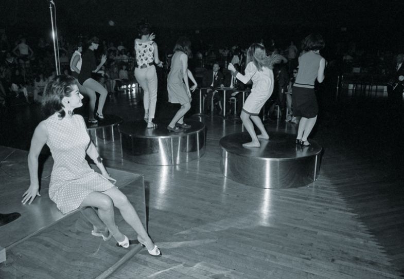 Michell Neville, 24, of Vichy, France, sits on the bandstand watching to illustrate Even wallflowers can flourish  girls dance at the Cheetah nightclub