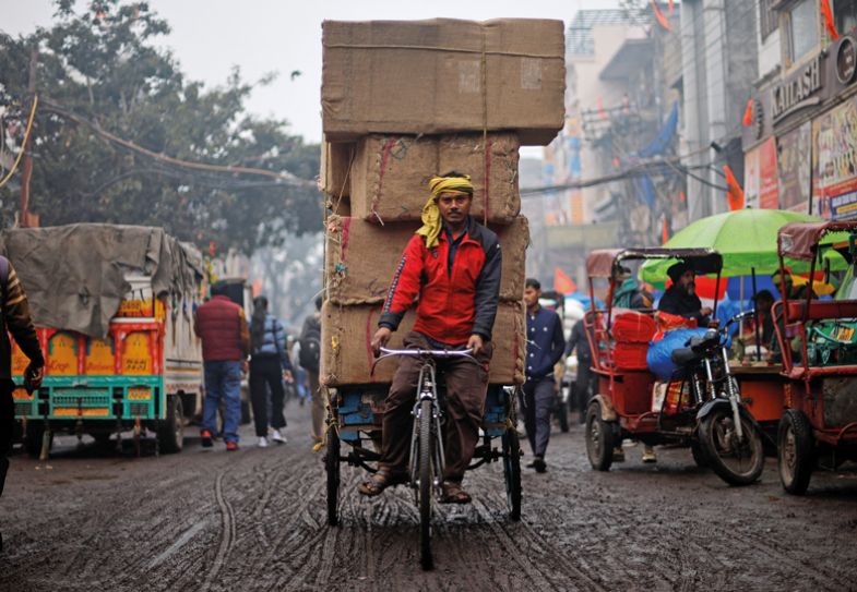 A man pulls a cart loaded with spice sacks at a wholesale market, a day before Indian Prime Minister Narendra Modi's government presents its final budget