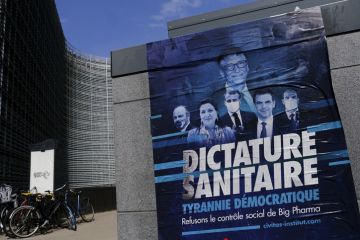 A poster of anti-vax movement in front of Berlaymont Building, the European Commission headquarters in the European district of Brussels, Belgium on April 19, 2021. stock photo