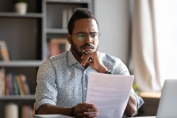 An African academic reads a thesis