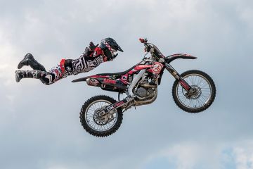 Motocross rider in mid-air illustrating university staff choosing to homeworking off campus