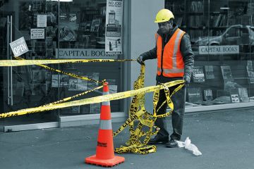 Worker putting up barrier tape