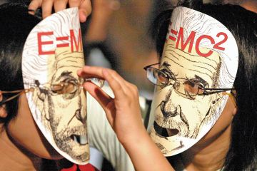 Two people wearing Einstein masks