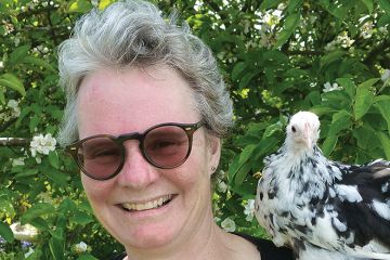 Author Emma Gee with a chicken on her shoulder