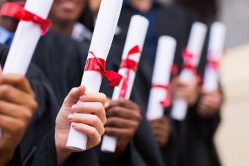 Group of graduates holding degree certificates