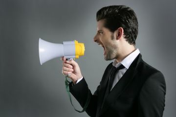 A man shouting into a megaphone, illustrating heckling