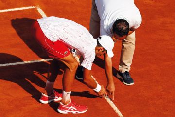 Novak Djokovic of Serbia inspects a line call with the umpire to illustrate Norwegian universities fear EU exclusion under technology rules