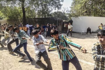 Young teenagers playing The game Tug of the war during Khel Maha Kumbh.