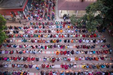 Thousands of Hindu devotees sits with Prodip and prays to God in front of Shri Shri Lokanath Brahmachari Ashram temple.