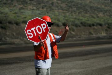 A man holds a 'stop' sign