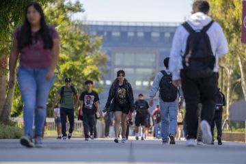 University students walk past the Natural Sciences and Mathematics build on the campus of Cal State University.