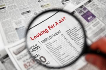 Magnifying glass searching job adverts illustrating graduate outcomes survey results