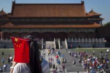 Young Chinese girl with a Chinese Flag in her head at the Forbidden City in the city of Beijing.