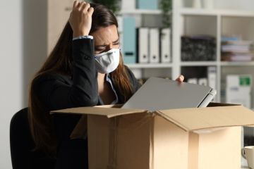 A woman packs her things after being fired