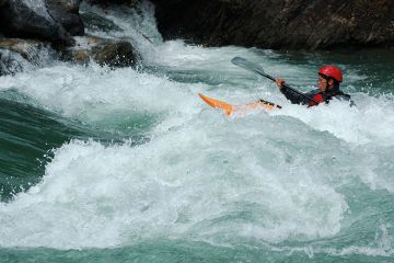 Person in a kayak paddling upstream. To illustrate that a one-off inflationary tuition fee rise will do little to help the financial instability of the higher education sector in England