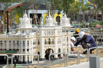 Construction workers work near a miniature of Kuala Lumpur's railway station. To illustrate how universities in Asia are responding to the fast growth of cities.