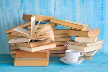 Piles of books with cup of tea