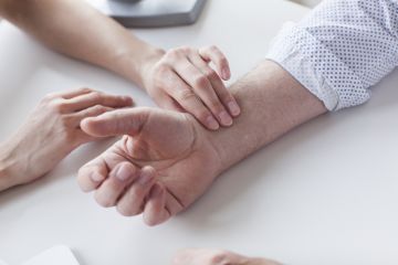 A doctor taking someone's pulse