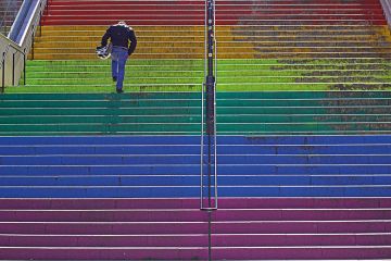 Person running up rainbow stairs to illustrate LGBTQ exam performance