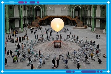 People pedal on bicycles equipped with dynamos which light up gigantic luminous bulbs as part of an art installation in Paris. To illustrate the mergers of universities in France.