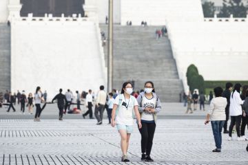 Taipei, Taiwan, March 2, 2020. Two Taiwanese girls, wearing a face mask to protect themselves from the novel coronavirus are walking in the Liberty Square, Taipei, Taiwan.