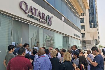 People gather outside a branch of Qatar Airways in the United Arab Emirate of Abu Dhabi on June 6 after ban on Qatari flights