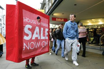 A man dressed as a 'shopping bag' advertises a department stores' post Christmas sales promotions on Oxford Street in central London