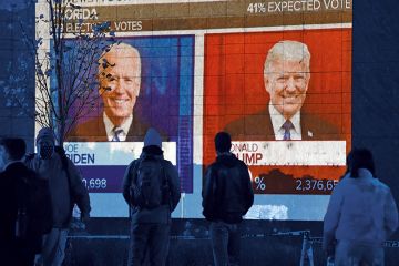 People watch a big screen displaying the live election results in Florida at Black Lives Matter plaza across from the White House on election day in Washington, DC on November 3, 2020.