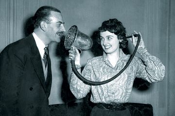 Woman demonstrating a Chase silver ear trumpet, made in 1880 and used by Queen Victoria, at the 'Escape From Deafness' exhibition in Park Lane House, Park Lane, London.