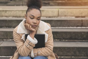 An unhappy black student waiting