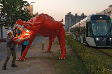 Dragon art installation outside the area of the Pier-2 Art Center in Kaohsiung, Taiwan with trams passing through to illustrate China ‘intimidating’ international academics travelling to Taiwan