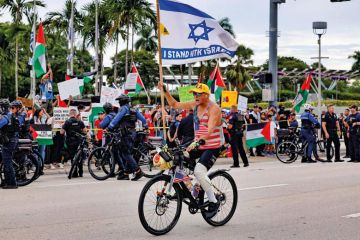 A pro-Israel protestor rides his bike along Biscayne Blvd to illustrate US campuses confront extent of donor influence after Israel rows