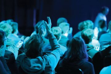 crowd gives applause at a conference event