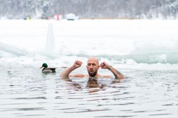 man ice bathing in the freezing cold water of a frozen lake among ducks to illustrate Norwegian universities brace for ‘entirely new economic reality’