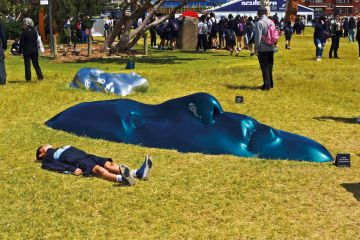 Sculpture exhibition of faces flat on the ground in Sydney, NSW, Australia to illustrate ‘Inflection point’ for disabilities in higher education