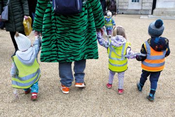 Young children in hi-vis jackets taken for a walk in London, England to illustrate Nursery time is over for UK campuses