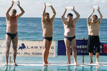 People carry ice blocks as they prepare to get into the pool next to the Pacific Ocean at Bondi Beach in Sydney.