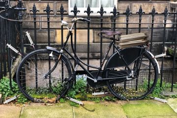 Old style bicycle with flat tyres chained up on fence railings with syringes around the wheels to illustrate Social research is being stymied by excessive ethical oversight