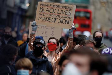 A protestor gestures during a demonstration called by the Rhodes Must Fall campaign