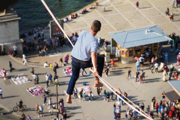 Tightrope walker Nathan Paulin traverses a slackline between the Eiffel Tower and the Trocadero Square to illustrate French universities avoid worst in election but face uncertainty