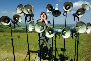 Composer and director of The Shout choir surrounded by megaphones on Devils Dyke, Sussex to illustrate Student complaints hit new record levels in England and Wales