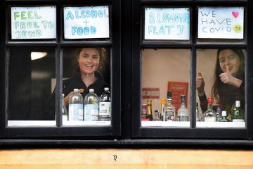 Students look out of the windows of the student accommodation who have been placed under covid-19 restrictions