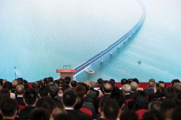 Guests watch a trailer on a giant screen during the opening ceremony of the Hong Kong-Zhuhai-Macau Bridge 