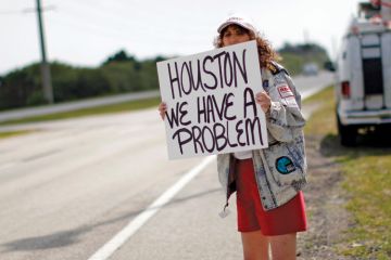 Woman holding 'Houston, we have a problem' sign