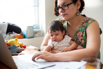 Working mum with baby in lap