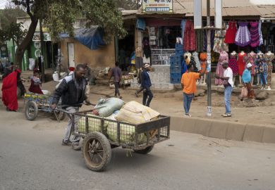 A porter pushing a cart full of parcels in the main street of Arusha, Tanzania