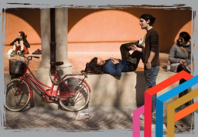 Students relax in the sunshine at the University of Bologna.