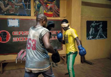 Boxers spar in gym, one of them blindfolded