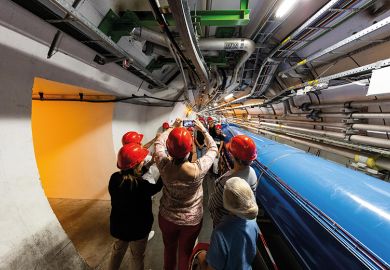 People in hard hats in tunnel at CERN lab